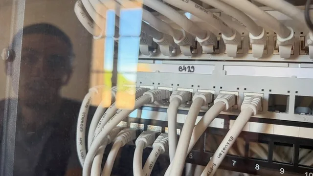 Câbles Ethernet raccordés aux panneaux de brassage d’une baie réseau