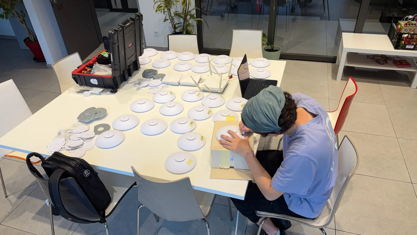 Un intervenant repère les bornes Wi-Fi sur une table de préparation